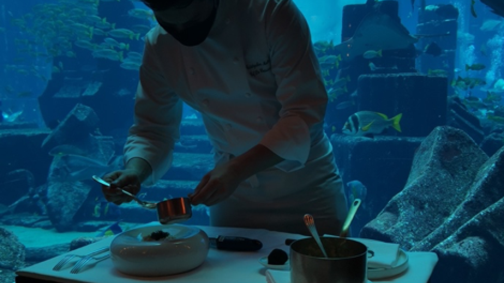 Chris Malone plating food in underwater restaurant